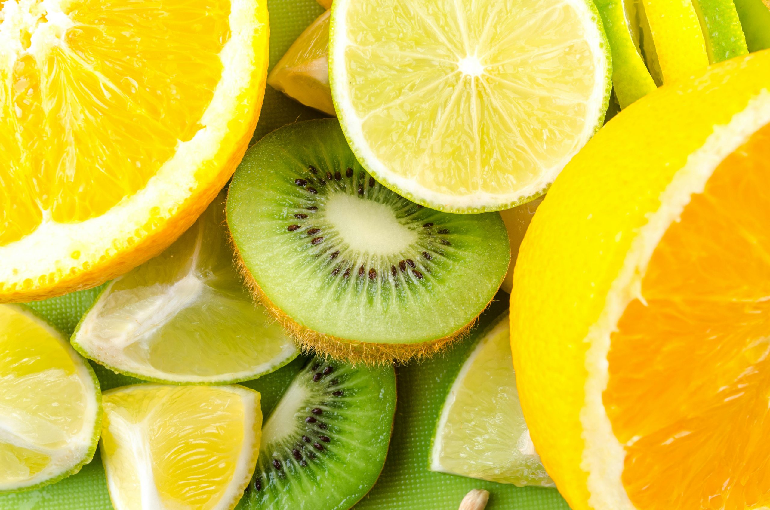 Close-up of fresh sliced citrus and kiwi fruits showcasing vibrant colors and textures.